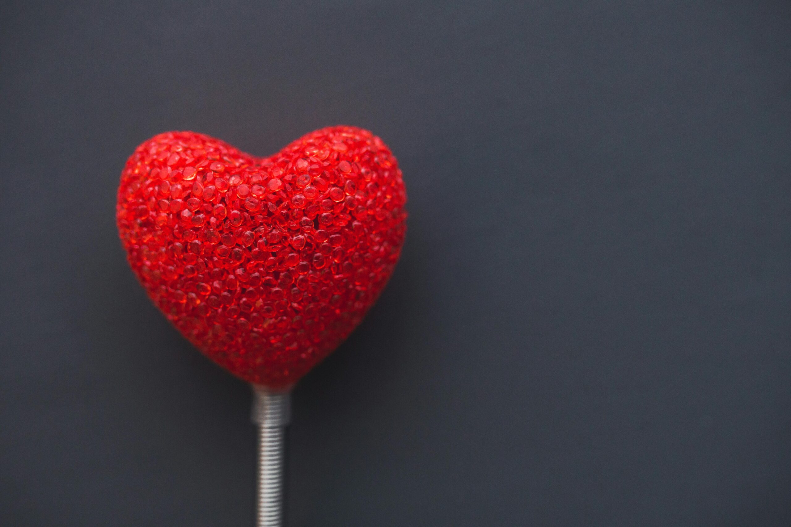 A vibrant red heart on a dark backdrop, symbolizing love and romance.