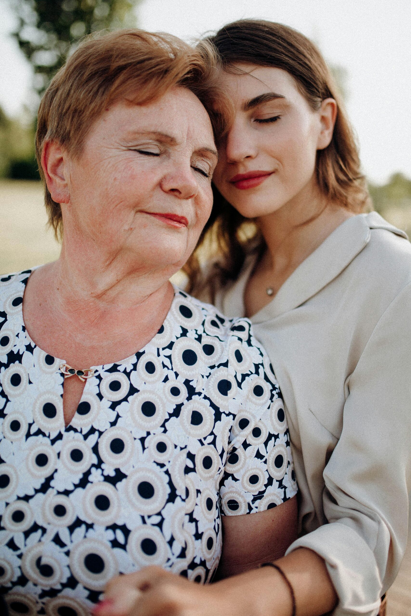 An affectionate embrace between a mother and daughter in a serene outdoor setting, radiating love and joy.